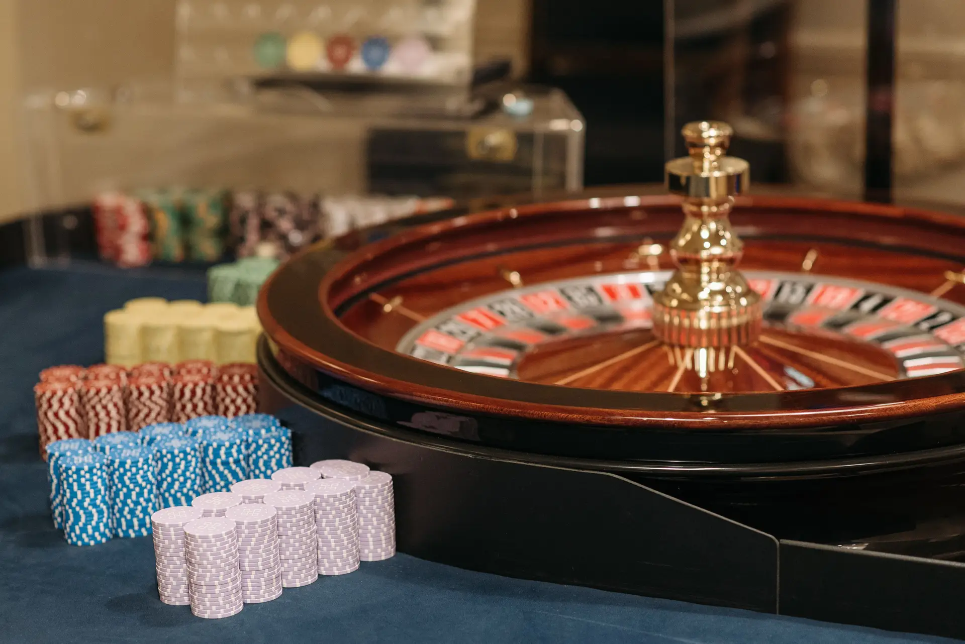 Close-up of stacked casino chips and gaming wheel